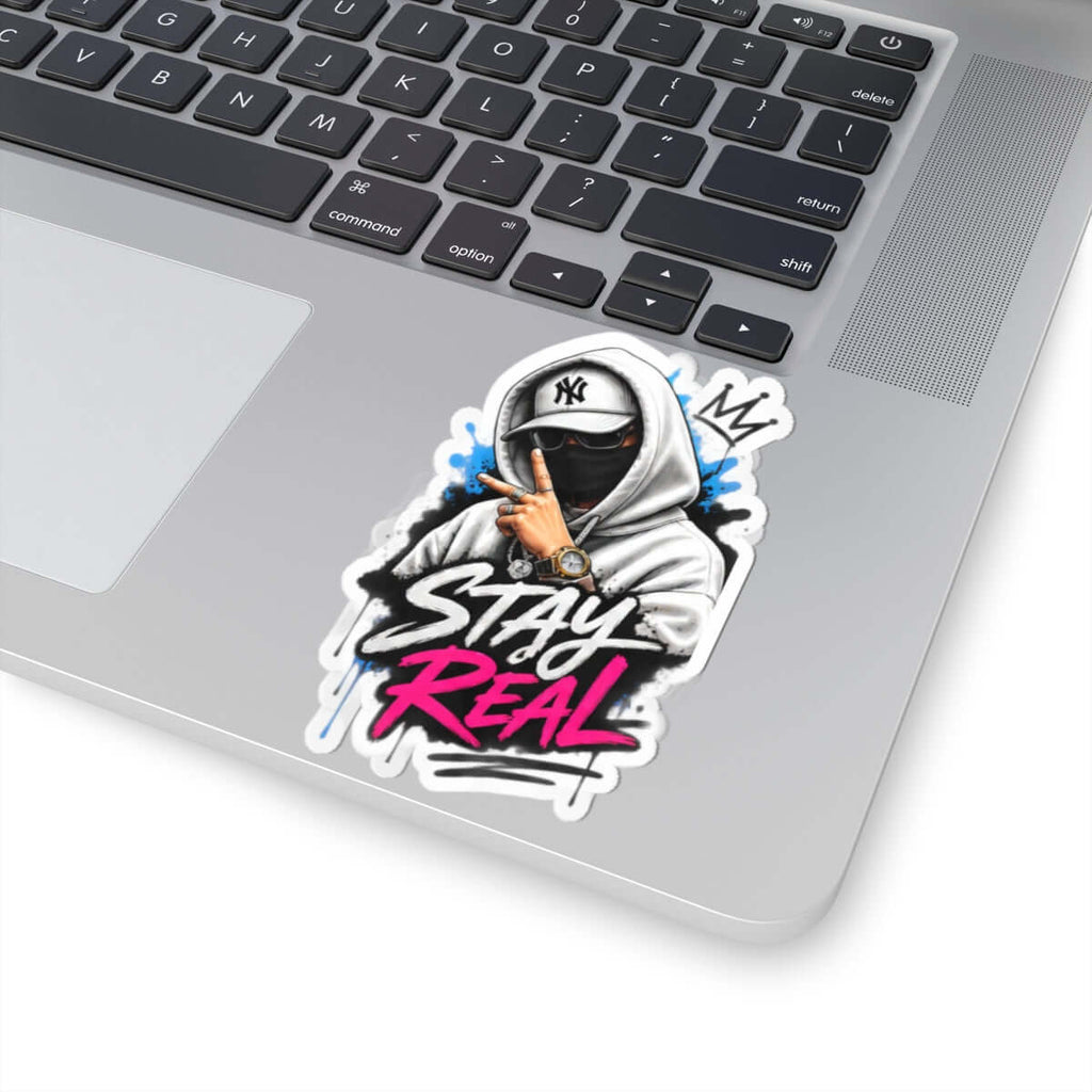 Custom kiss-cut stickers featuring a stylish design that reads 'STAY REAL' on a laptop surface.